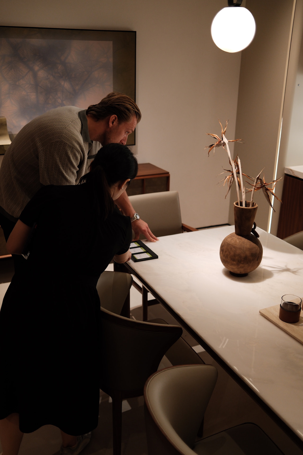 Frank reviewing product details with a supplier at a work table